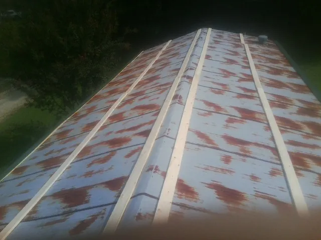 Rusted metal roof panels with new wood purlins before replacement — Storm Damage Roof Repair in Linden by Roofing Brothers